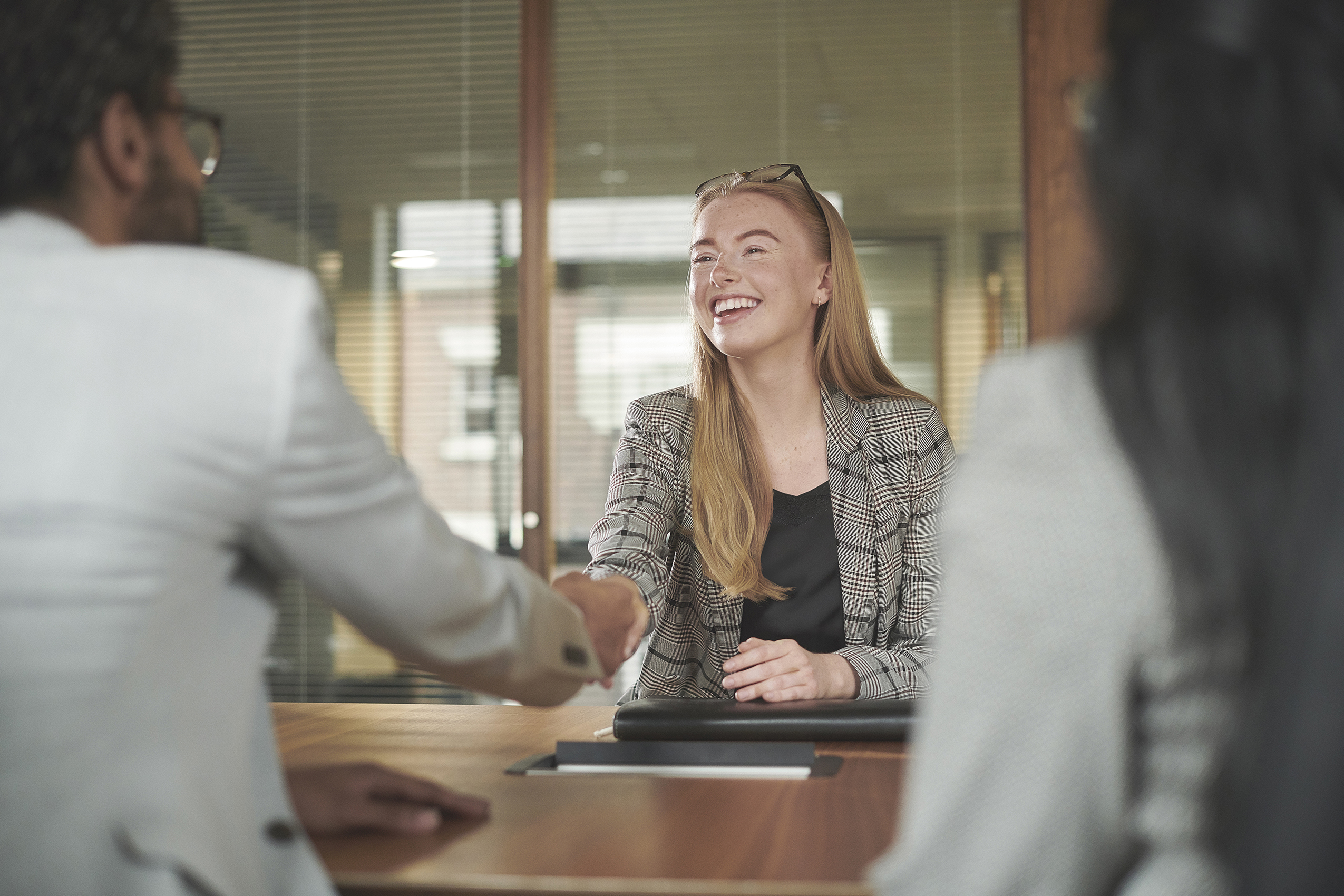 Woman shaking hands with colleague.